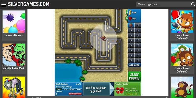 Bloons Tower Defense 4 with monkey towers along the track while a wave of balloons comes through