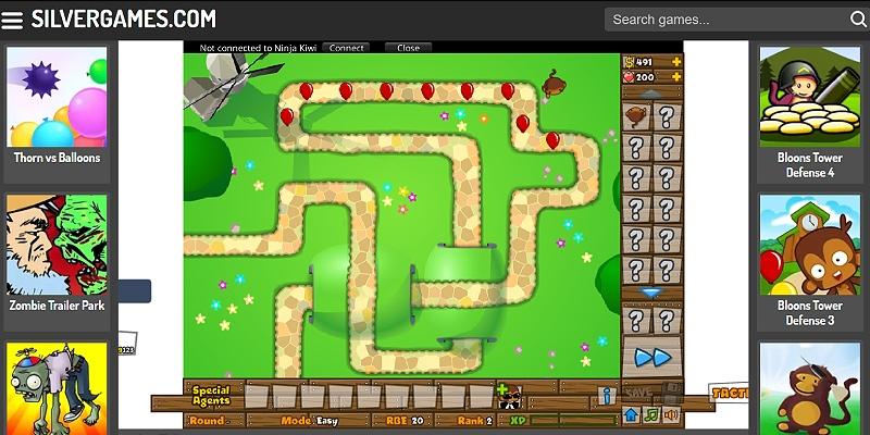 Screenshot of Bloons Tower Defense 5 on Silvergames: monkey towers along the track popping a wave of bloons